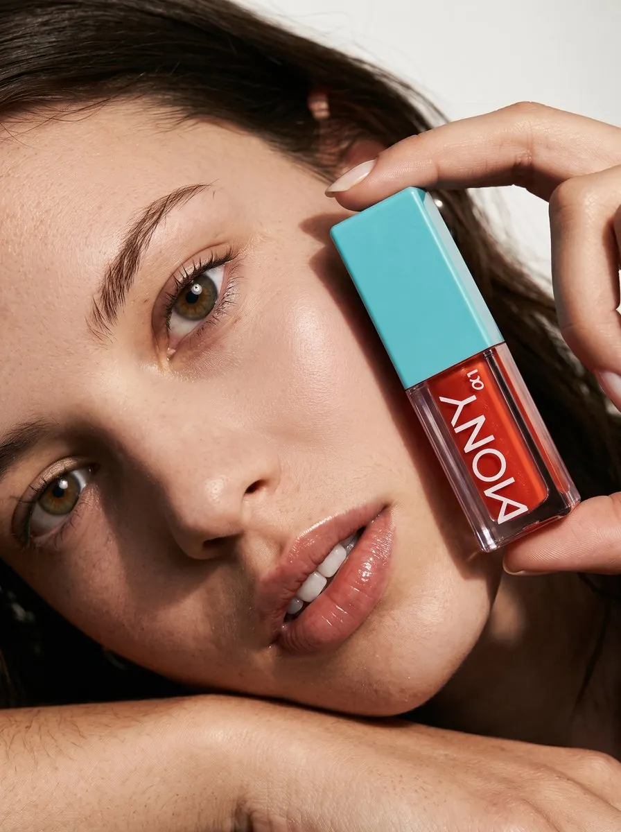 Lifestyle brand Instagram ad creative: model holding a MONY lip gloss next to her face